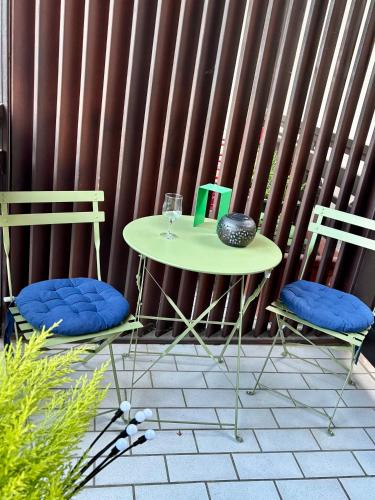 a table with two chairs and a table with a glass at Une Place A Part in Obernai
