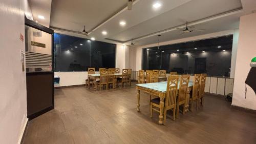 a dining room with a table and wooden chairs at Hotel Yogasthali - Top Rated !! Most Awarded !! Luxury Rooms !! Lift !! Parking in Rishīkesh