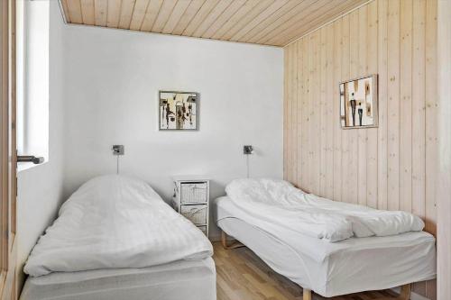 two beds in a room with white walls at 115-Harboore-Strandvejen-164 in Harboør
