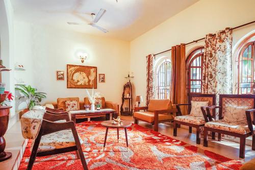 a living room with chairs and a couch at Bougain Blossom Spacez Luxury Villa with Terrace Garden in Bengaluru