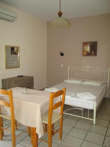 a bedroom with a bed and a table and chairs at Erminia Studios in Mousata