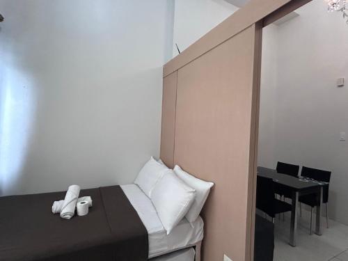 a small bedroom with a bed and a table at Wind and Sea at Wind Residences in Tagaytay