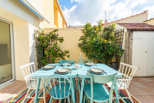 a blue table and chairs on a patio at Maison au cœur de la Chaume Garage fermé in Les Sables-dʼOlonne
