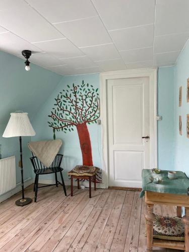 a room with a tree mural on the wall at TroldeSlottet in Rudkøbing