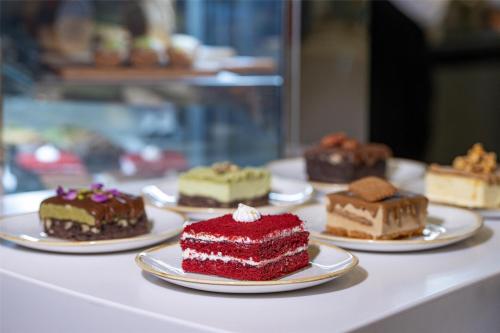 a bunch of different cakes on plates on a table at Radisson Blu Hotel Riyadh Convention and Exhibition Center in Riyadh