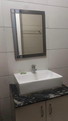 a white sink in a bathroom with a mirror at Hotel Yogasthali - Top Rated !! Most Awarded !! Luxury Rooms !! Lift !! Parking in Rishīkesh