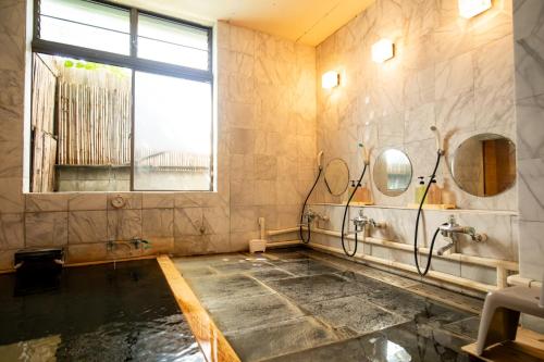 a bathroom with a pool of water and a window at Shimaya in Yamanouchi