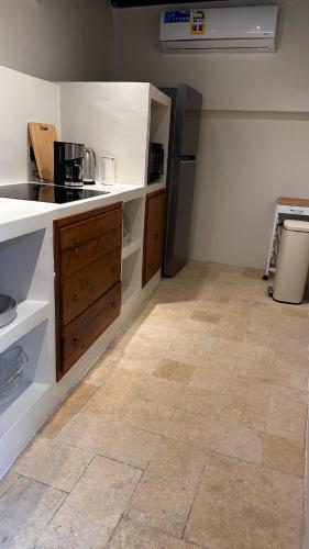 a kitchen with a stove and a refrigerator at Bait Rawiyah experience an authentic Omani house in Muscat