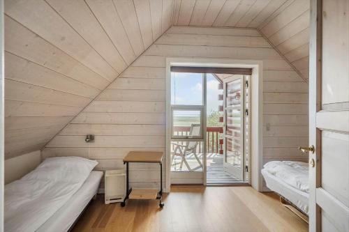 a room with a bed and a desk and a balcony at 289-Harboore-Strandvejen-179 in Harboør