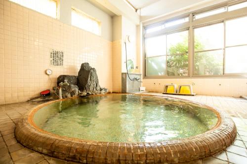 a large pool of water in a bath room at Shimaya in Yamanouchi