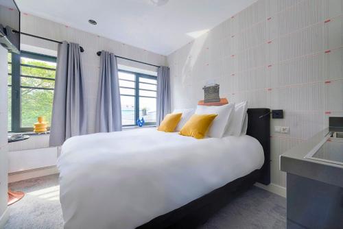 a bedroom with a large white bed with yellow pillows at Freshly Renovated Stay w kitchen and bathroom in Tilburg