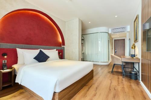 a hotel room with a large bed and a desk at Kin Hotel Hai Ba Trung in Ho Chi Minh City