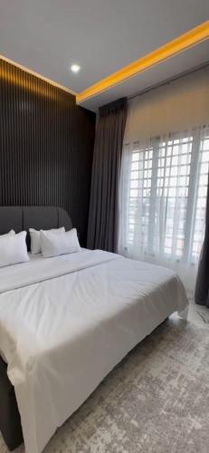 Un dormitorio con una gran cama blanca con ventana. en Luxury 2 bedroom, en Lagos