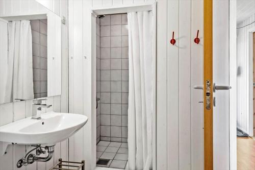 a white bathroom with a sink and a shower at G219-Lemvig-Skovstjernevej-19 in Lemvig