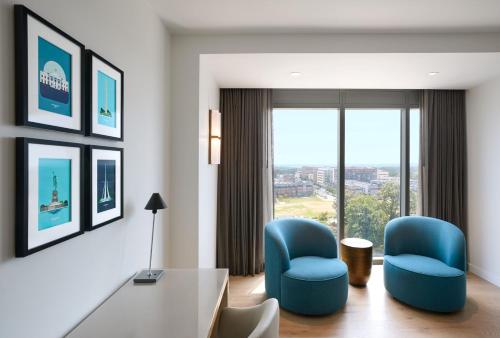 a living room with two blue chairs and a table at JW Marriott Reston Station in Reston