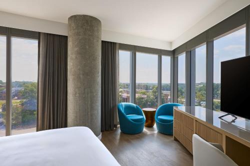 a hotel room with a bed and two blue chairs at JW Marriott Reston Station in Reston