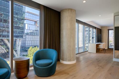 a lobby with a blue chair and large windows at JW Marriott Reston Station in Reston