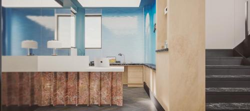 a bathroom with blue walls and a sink and stairs at Hotel Ben Marsalforn, Affiliated by Meliá in Marsalforn