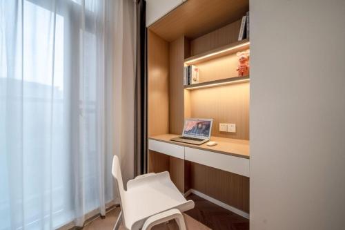 a room with a desk with a laptop and a chair at Shanghai Hills&Mico Hotel Residences Near Changshou Road in Shanghai