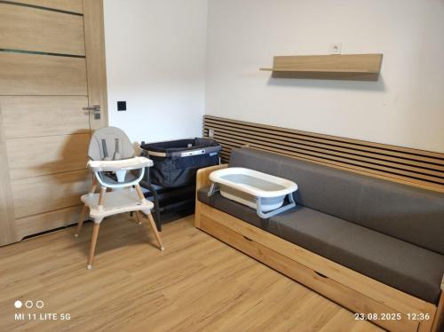 a bedroom with a bed and a chair and a table at Ośrodek Wypoczynkowy Sosenka in Załom