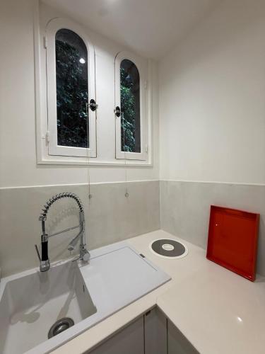 a kitchen with a sink and two windows at Innocent VI face au palais in Avignon