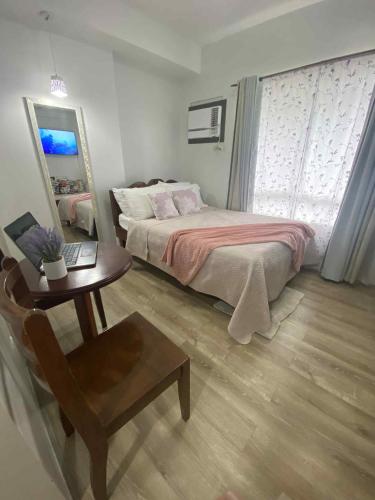 a bedroom with a bed and a table and a mirror at Isabela 1 Mesavirre Residences in Bacolod