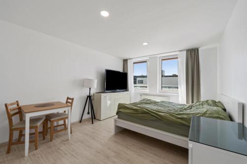 a bedroom with a bed and a desk and a table at Köln,Leverkusen Appartement Bahnhof,Innenstadt,Messe in Leverkusen