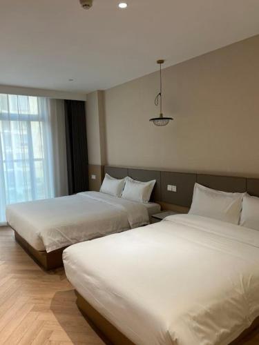 two beds in a hotel room with at Shanghai Hills&Mico Hotel Residences Near Changshou Road in Shanghai
