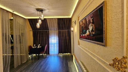 a dining room with a table and a painting on the wall at City Hotel Baku in Baku