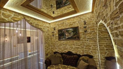 a living room with a stone wall with a chair at City Hotel Baku in Baku