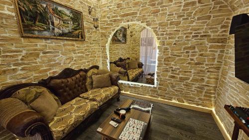 a living room with a couch and a stone wall at City Hotel Baku in Baku