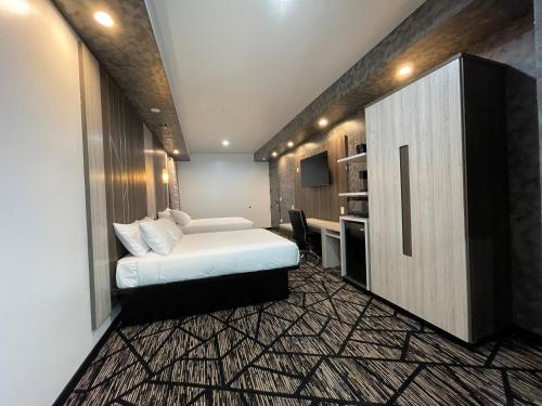 a bedroom with a bed and a cabinet and a desk at Comfeeni Inn and Suites in Houston