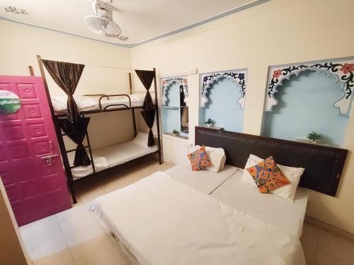 a room with a bed and a bunk bed at Hanuman Ghat Boutique Stays by Cafe Helsinki in Udaipur