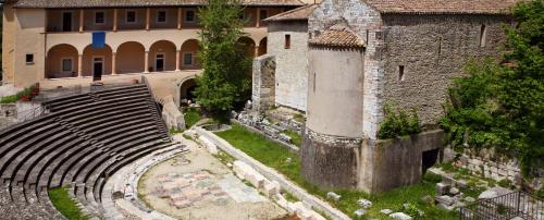 an ancient amphitheater in a city with a building at Torre Paola Dimora romantica in Acquasparta