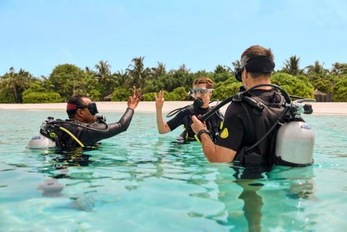 a group of three people in the water at ROBINSON NOONU - All Inclusive in Manadhoo