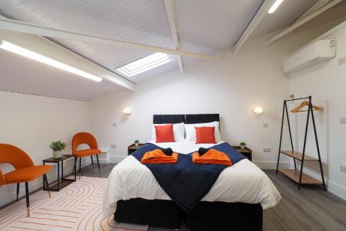 a bedroom with a large bed with orange pillows at Private & Peaceful Double Ensuite Rooms in Stapleford in Stapleford