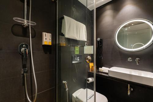 a bathroom with a shower and a toilet and a mirror at Gaas BaasCo in Kathmandu