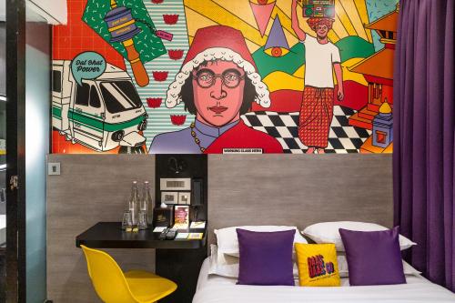 a bedroom with a bed with purple pillows and a mural at Gaas BaasCo in Kathmandu