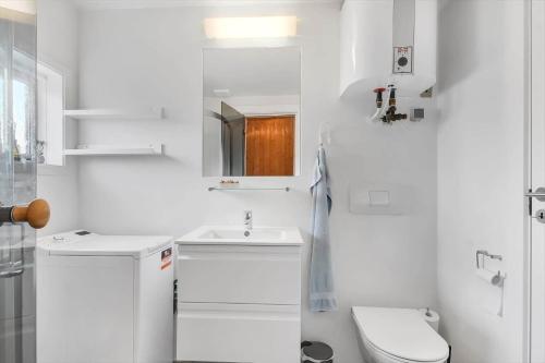 a white bathroom with a toilet and a sink at 163-Harboore-Vejlby-Klit-47 in Harboør