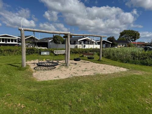 a park with a swing set in the grass at Cozy Cottage With A View Of Kerteminde Fjord in Munkebo
