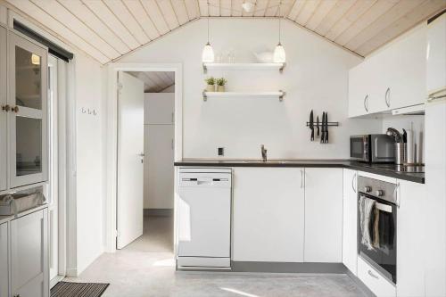 a white kitchen with white cabinets and appliances at 509-Lemvig-Stranden-11 in Lemvig