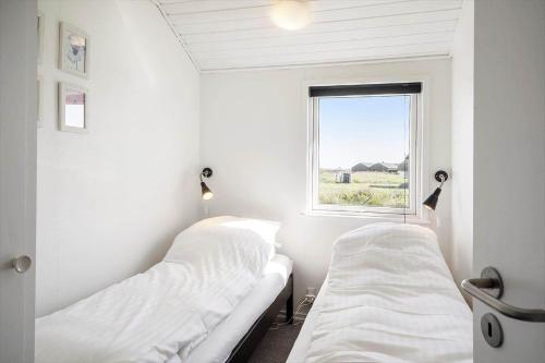 two beds in a white room with a window at 509-Lemvig-Stranden-11 in Lemvig