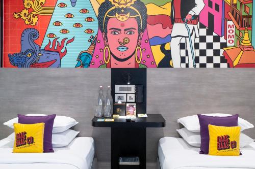 a room with two beds and a painting on the wall at Gaas BaasCo in Kathmandu