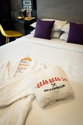 two beds with white sheets and a bag on them at Gaas BaasCo in Kathmandu