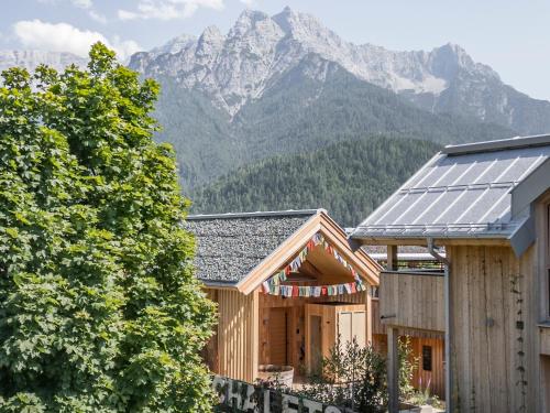 a house with solar panels in front of a mountain at Alpegg Chalets in Waidring