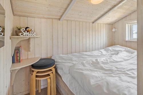 a small bedroom with a bed and a stool at 510-Lemvig-Lyngsletten-28 in Lemvig