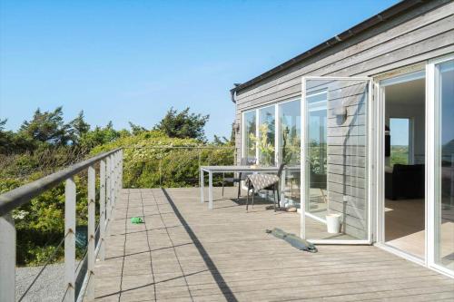 a wooden deck with a table and glass doors at 523-Lemvig-Gammel-damsgardvej-8 in Lemvig