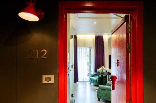 a hallway with a red door and a living room at Gaas BaasCo in Kathmandu