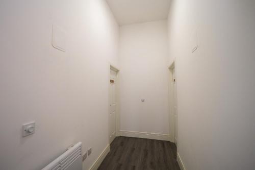 an empty hallway with white walls and wood floors at Private & Peaceful Double Ensuite Rooms in Stapleford in Stapleford