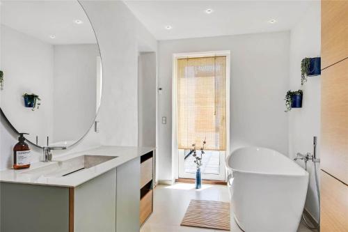 a white bathroom with a sink and a mirror at 712-Thyboron-Vesterhavsgade-30 in Thyborøn